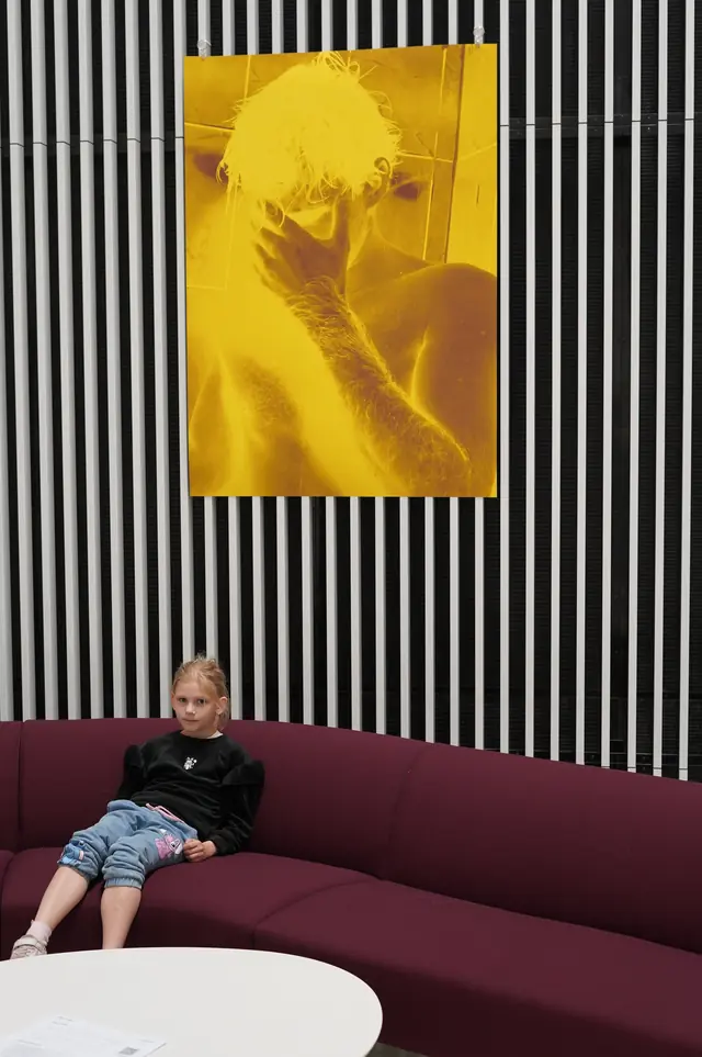 Gelbes Bild vor der schwarz-weißen Wand der Philharmonie.