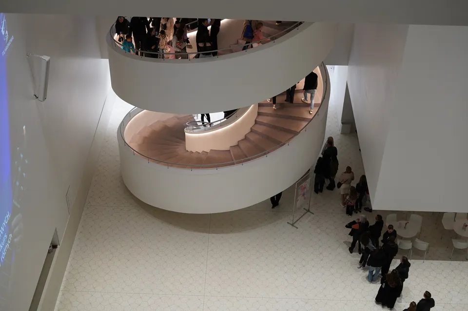 Biała spiralna klatka schodowa muzeum z zwiedzającymi na dole